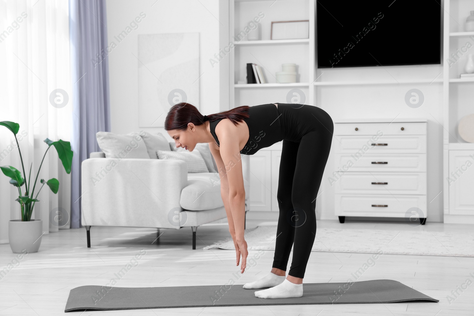 Photo of Morning routine. Woman doing stretching exercise at home