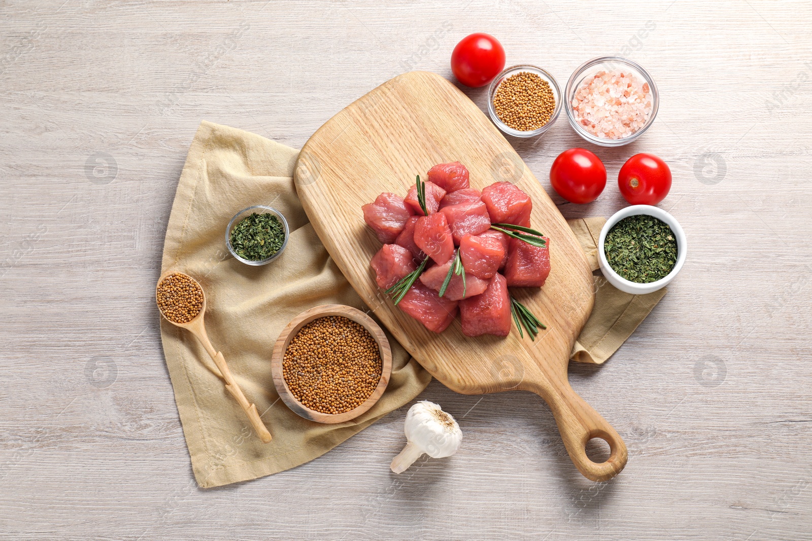 Photo of Raw beef meat and different ingredients for cooking delicious goulash on light wooden table, flat lay