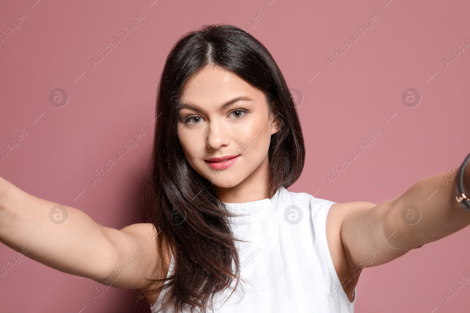 Photo of Attractive young woman taking selfie on color background