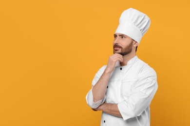 Photo of Thoughtful mature chef on orange background, space for text
