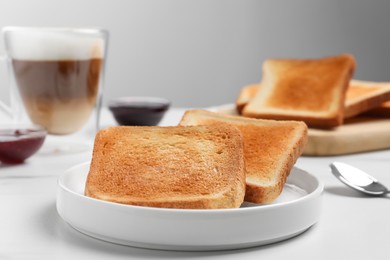Photo of Slices of tasty toasted bread on white table, closeup