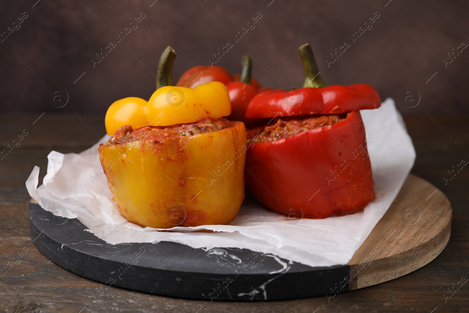 Photo of Delicious stuffed bell peppers served on wooden table