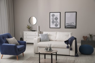 Photo of Stylish living room interior with white sofa, armchair and small coffee table