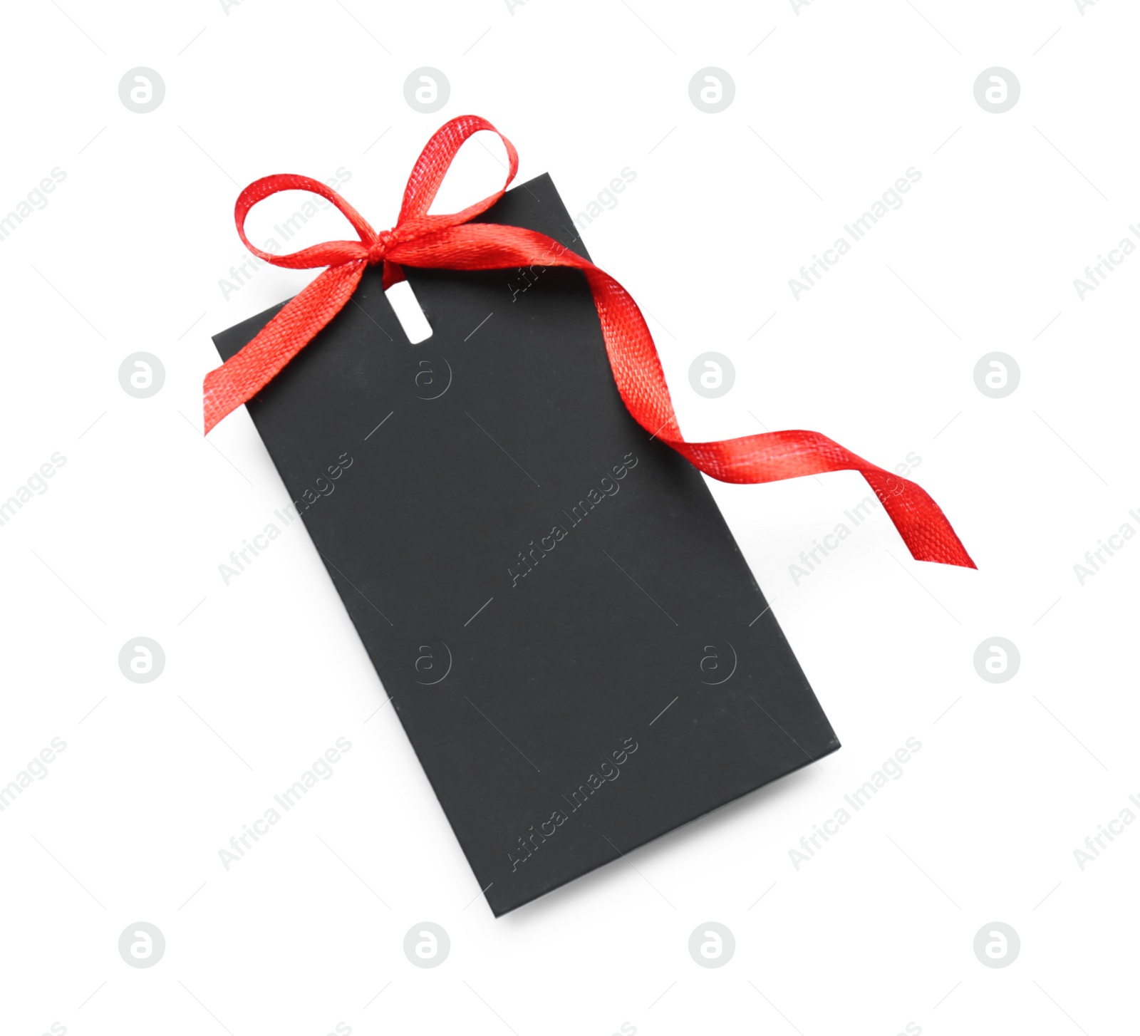 Photo of Blank black gift tag with red satin ribbon on white background, top view. Space for design