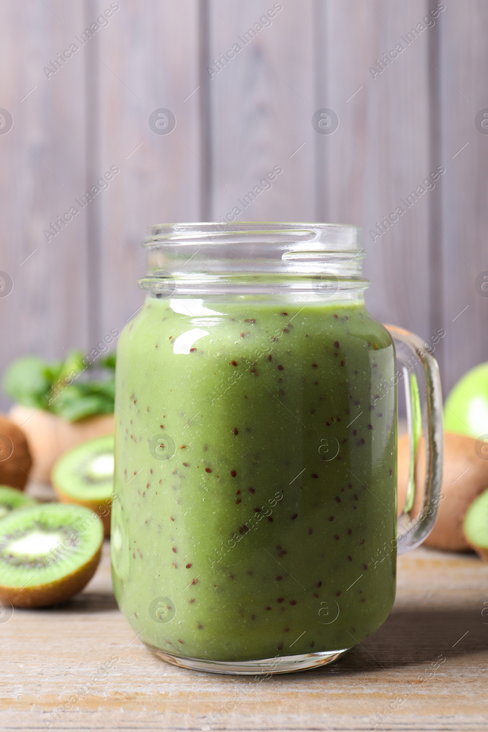 Photo of Delicious kiwi smoothie and fresh fruits on wooden table