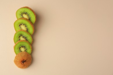 Sliced fresh kiwi on beige background, flat lay. Space for text