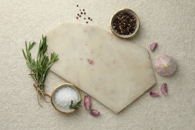 Photo of Cutting board, salt, pepper, rosemary and garlic on white textured table, flat lay. Space for text