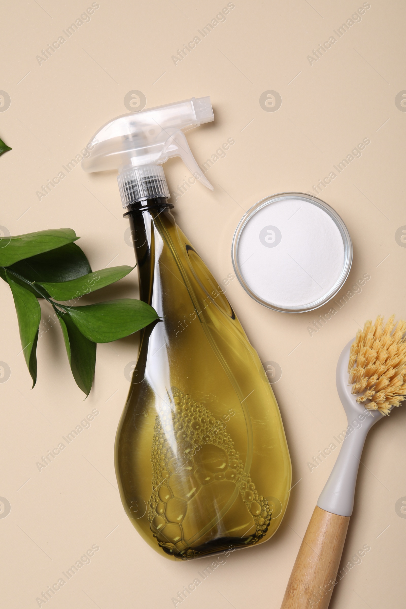 Photo of Bottle of cleaning product, brush and baking soda on beige background, flat lay