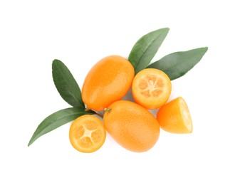 Photo of Whole and cut ripe kumquats with leaves on white background, top view. Exotic fruit