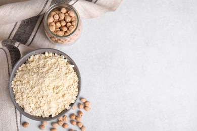 Chickpea flour in bowl and seeds on light grey table, flat lay. Space for text