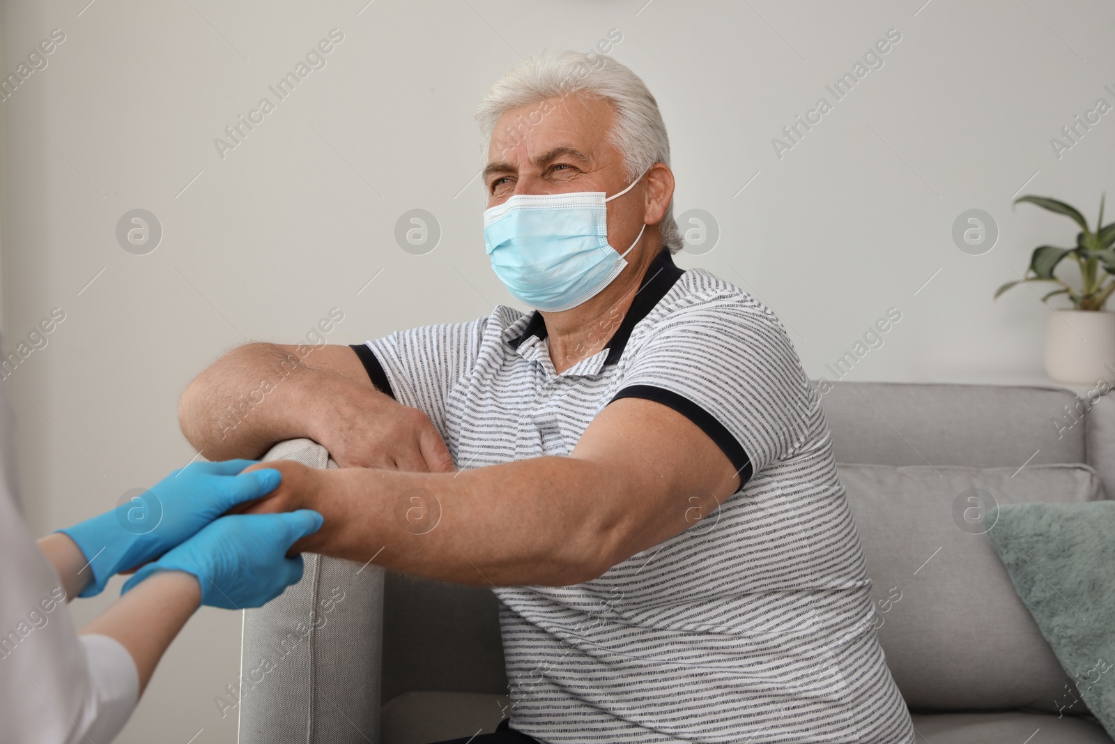 Photo of Doctor taking care of senior man with protective mask at nursing home