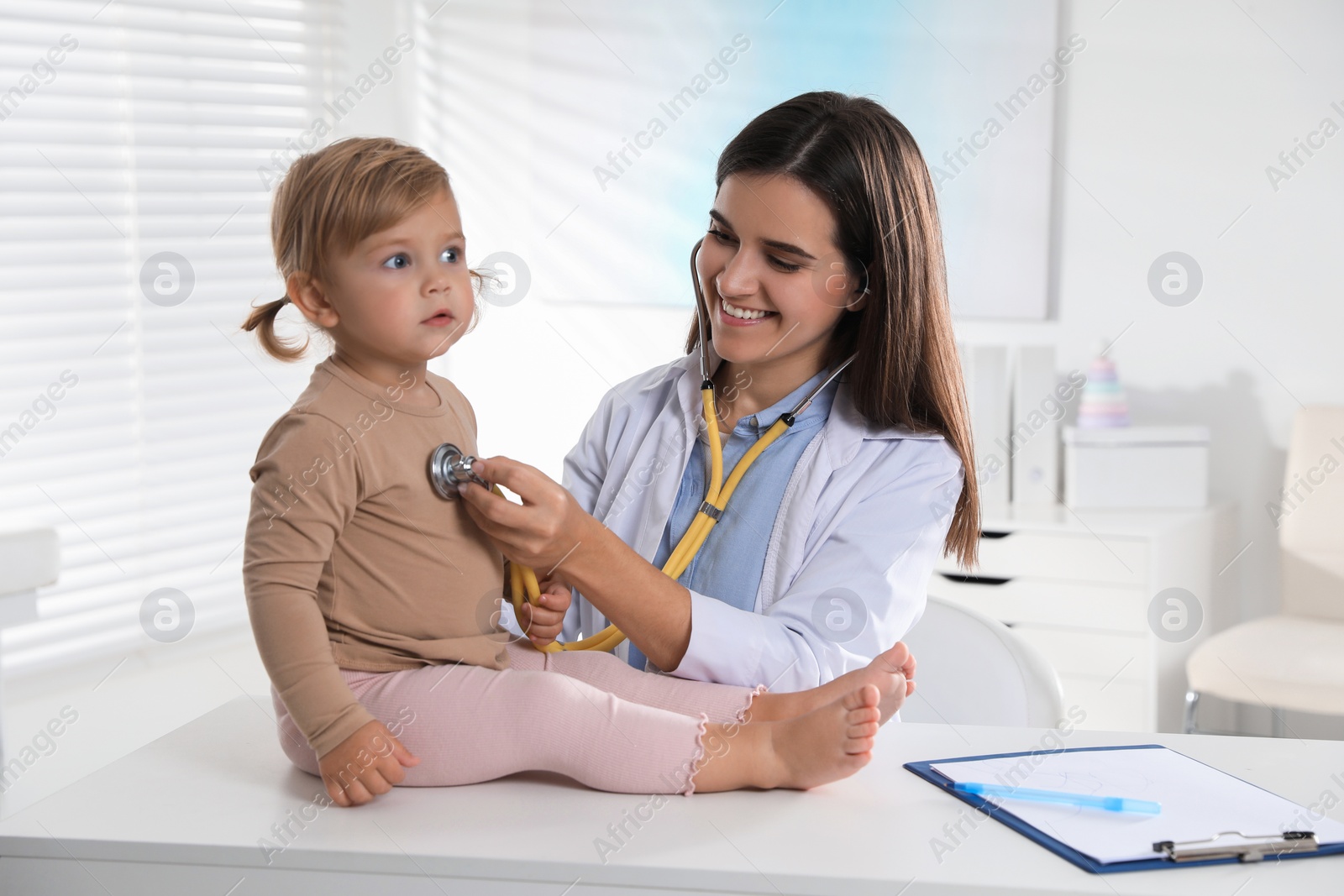 Photo of Pediatrician examining baby with stethoscope in clinic