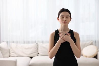 Beautiful girl meditating at home. Practicing yoga