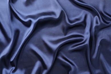 Photo of Crumpled dark blue silk fabric as background, top view