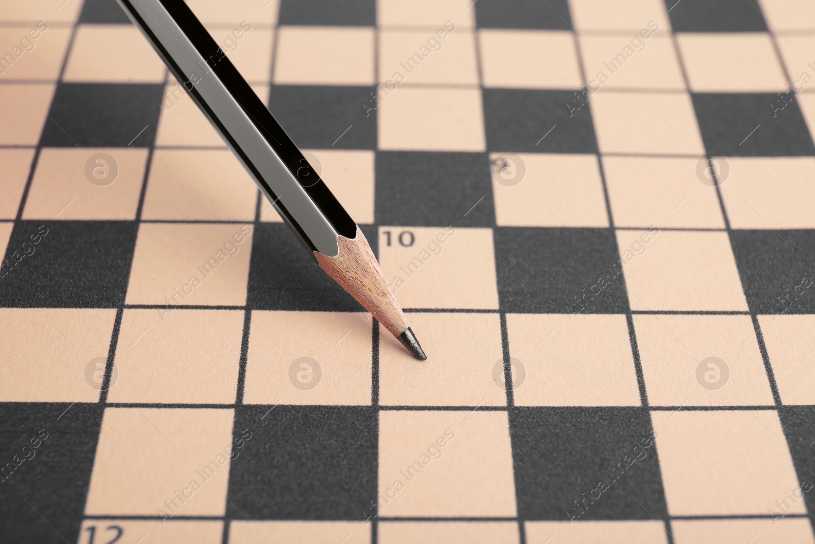 Photo of Pencil and blank crossword, closeup. Space for text