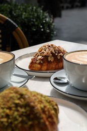 Delicious croissants and coffee on white table