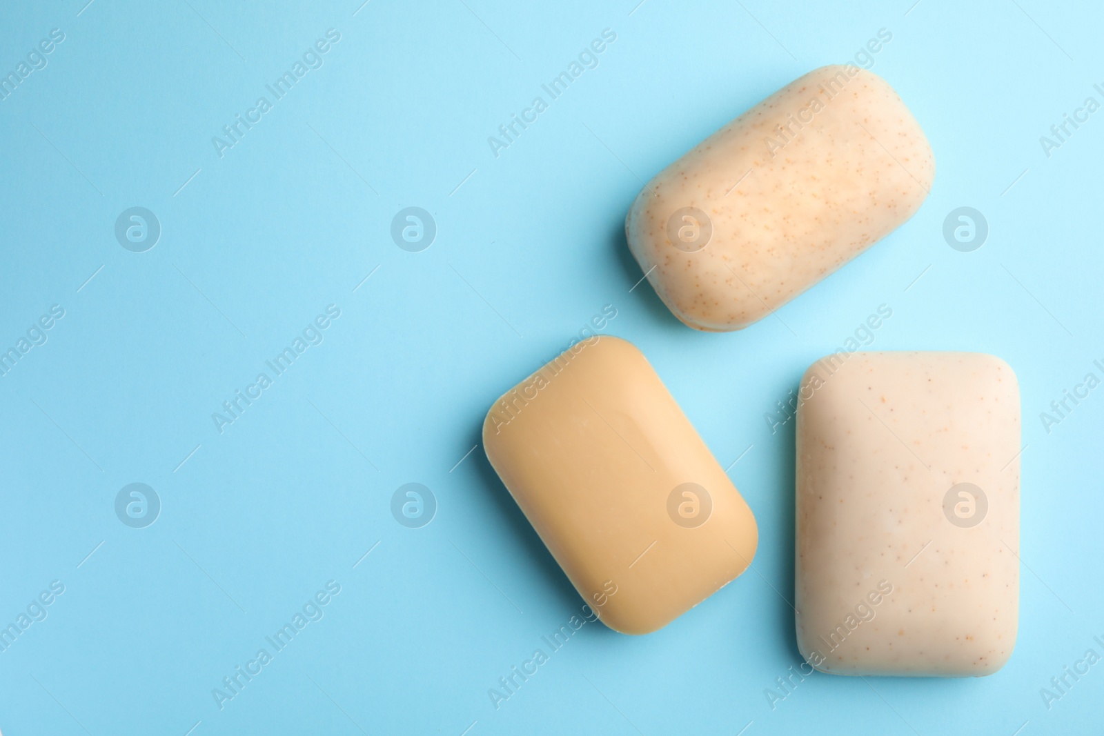 Photo of Different soap bars and space for text on color background, top view