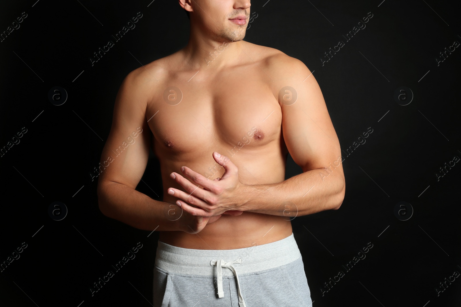 Photo of Man with sexy body on black background, closeup