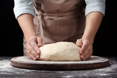 Female baker preparing bread dough at table, closeup