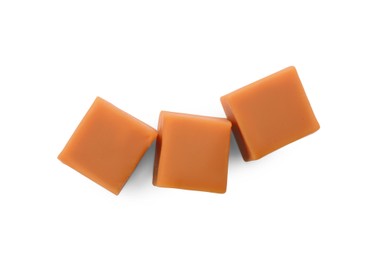 Photo of Heap of caramel candies on white background, top view