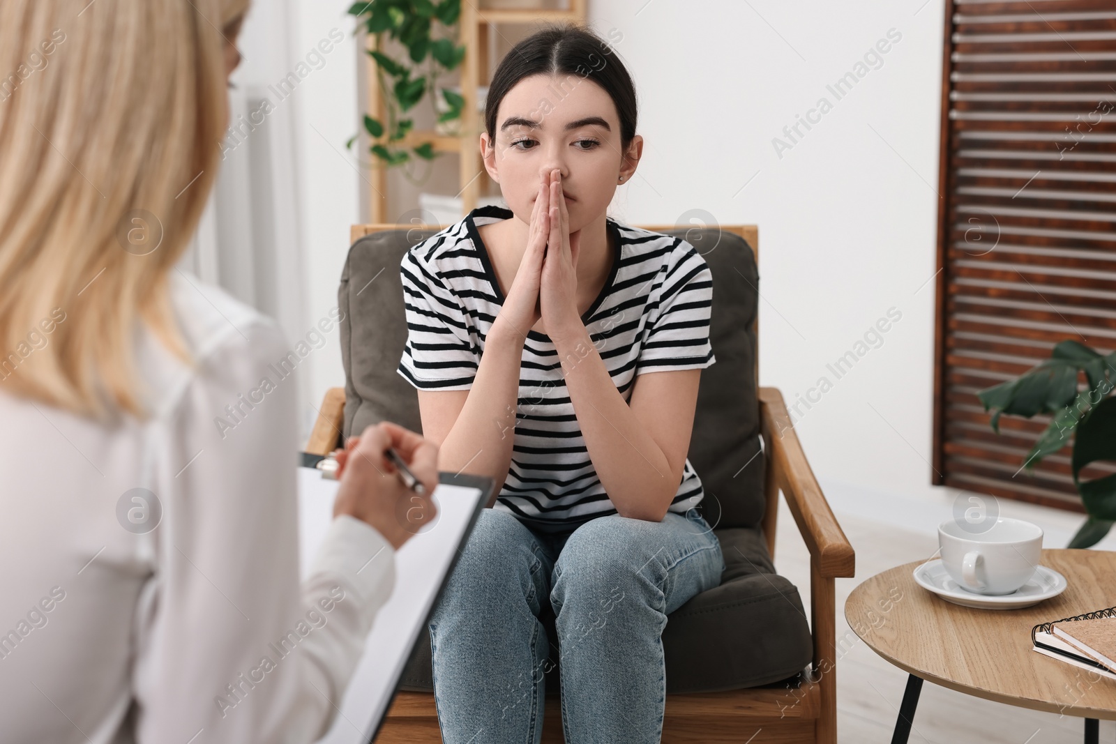 Photo of Psychologist working with teenage girl in office