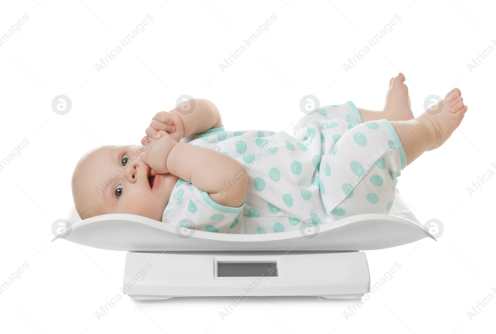 Photo of Cute little baby lying on scales against white background