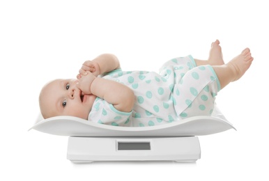 Cute little baby lying on scales against white background