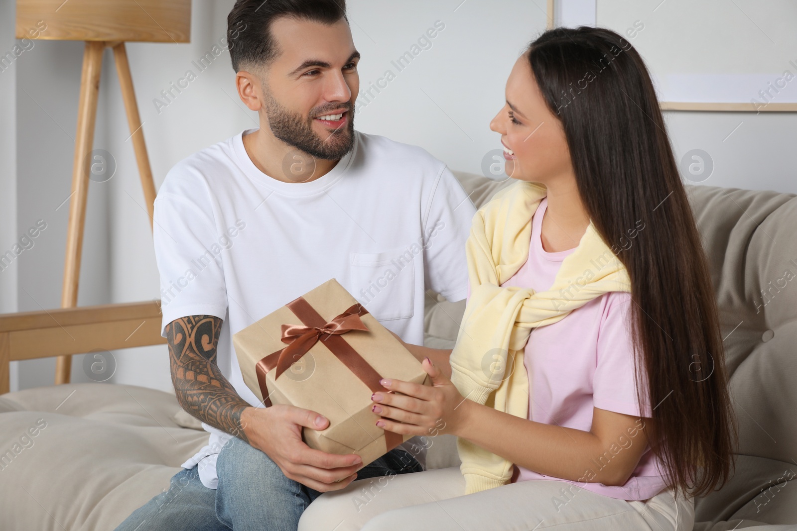 Photo of Lovely couple with beautiful gift at home