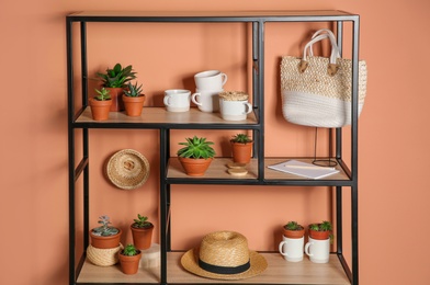 Stylish shelving unit with decorative elements near color wall. Interior design