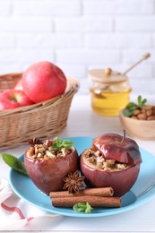 Photo of Tasty baked apples with nuts, honey, spices and mint on white wooden table