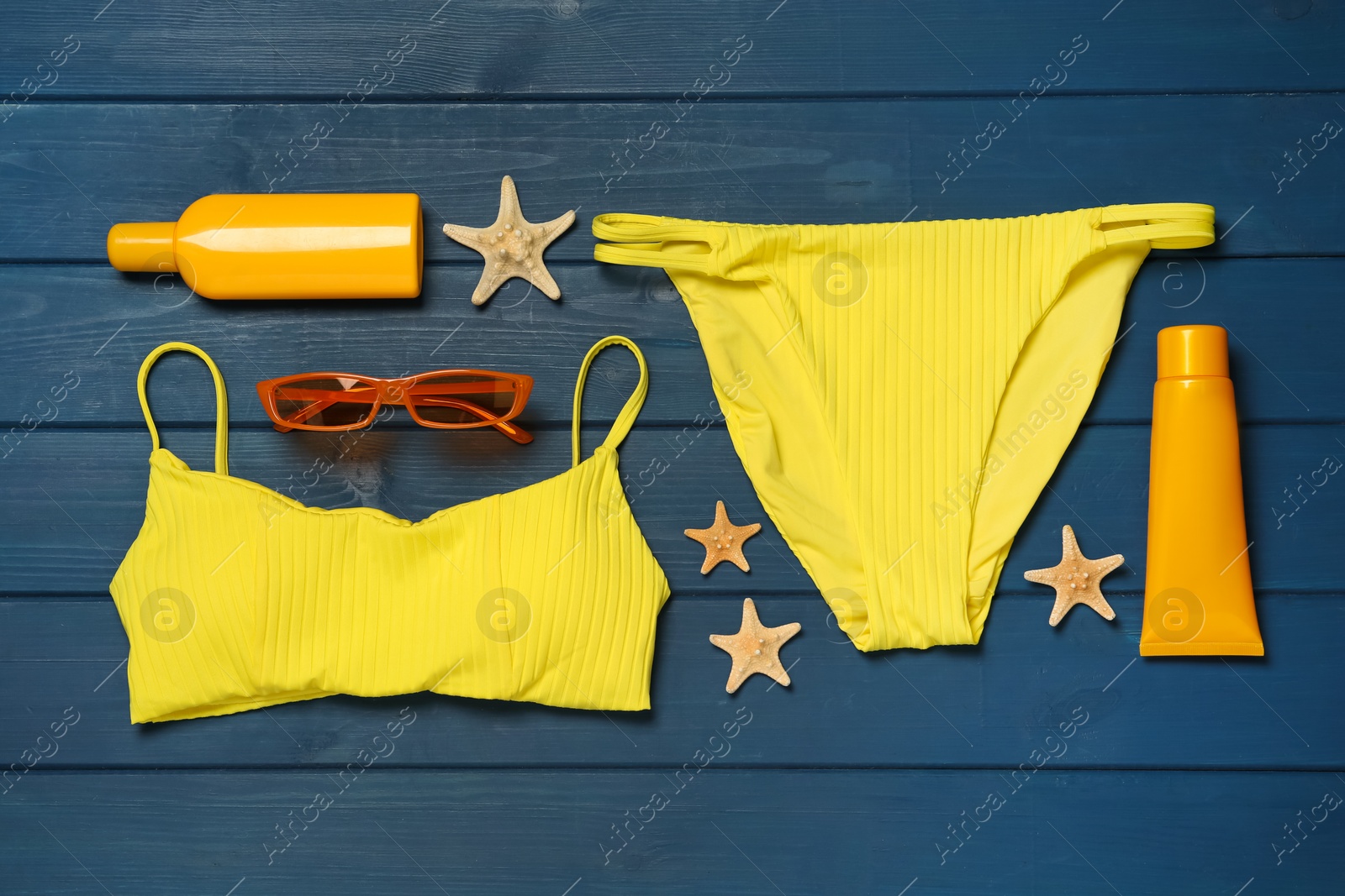 Photo of Flat lay composition with beach accessories on blue wooden background
