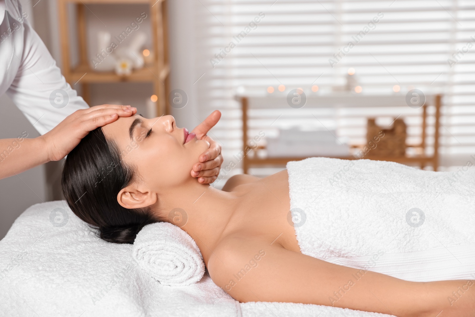 Photo of Beautiful woman receiving massage in beauty salon, closeup