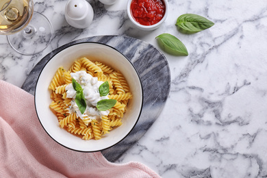Photo of Delicious pasta with sauce served on white marble table, flat lay