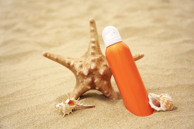 Sunscreen, starfish and seashells on sand. Sun protection care
