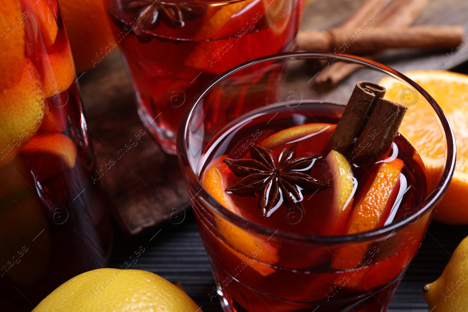 Photo of Aromatic punch drink and ingredients on table, closeup