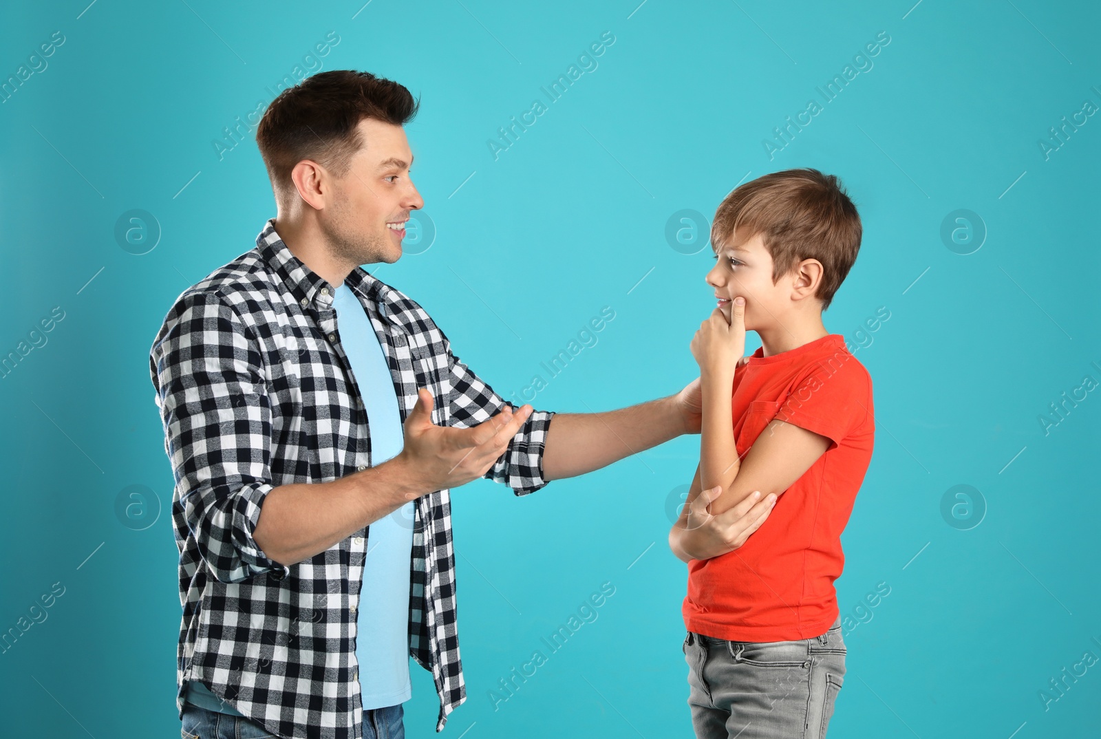 Photo of Dad talking with his son on color background