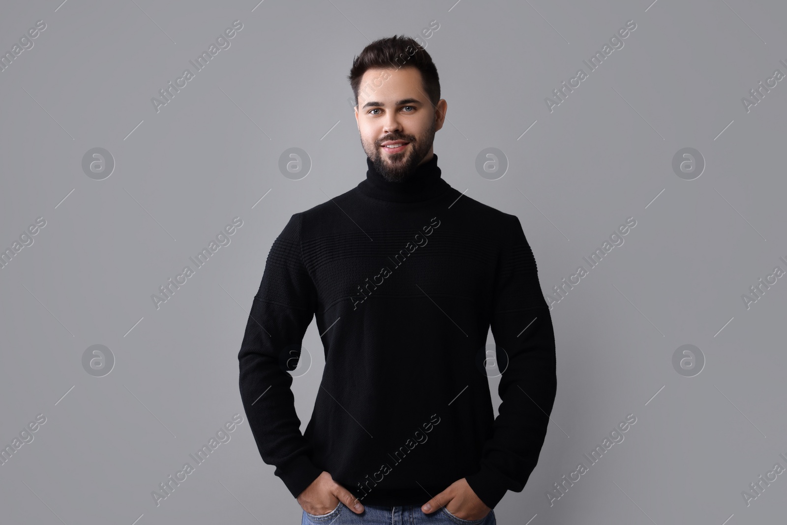 Photo of Happy man in stylish black sweater on grey background