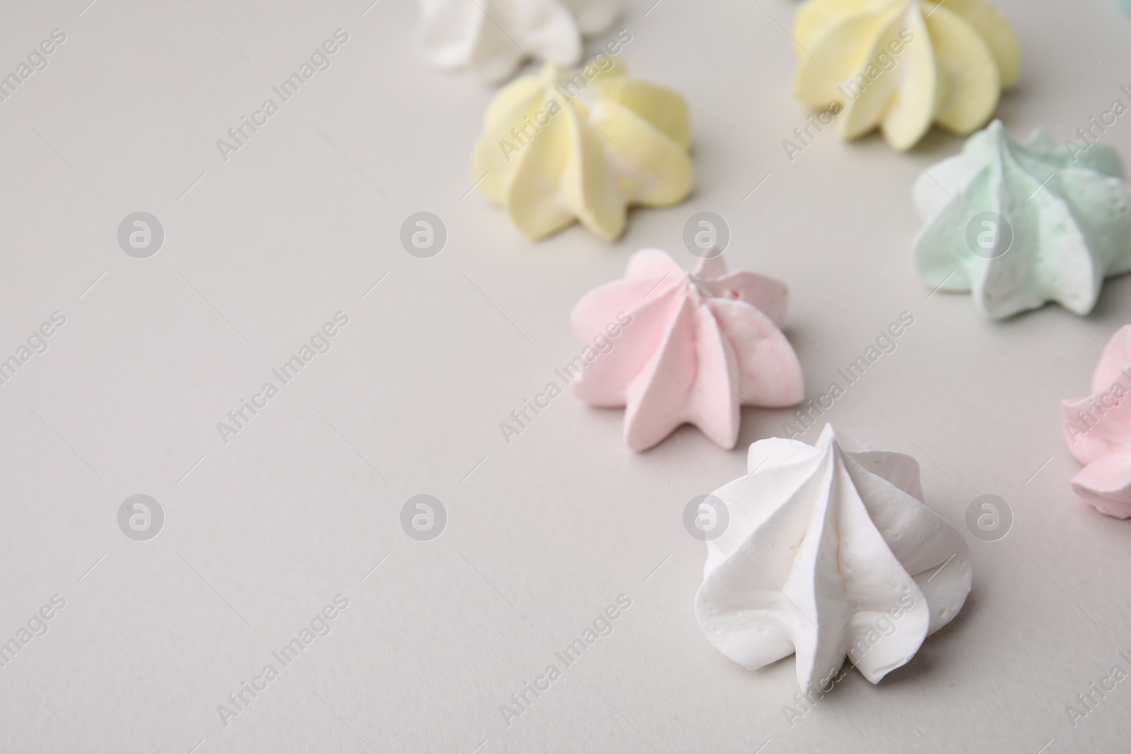 Photo of Delicious meringue cookies on light background, closeup. Space for text