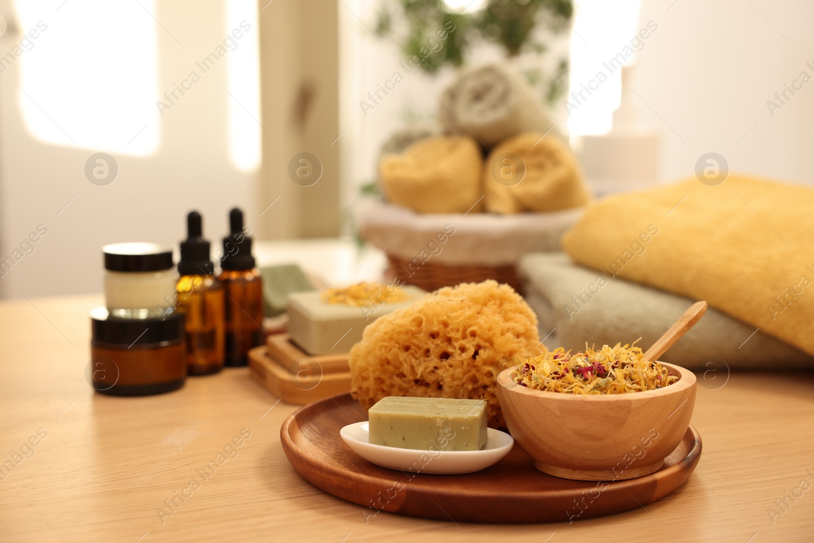 Photo of Dry flowers, loofah and soap bar on wooden table indoors, space for text. Spa time