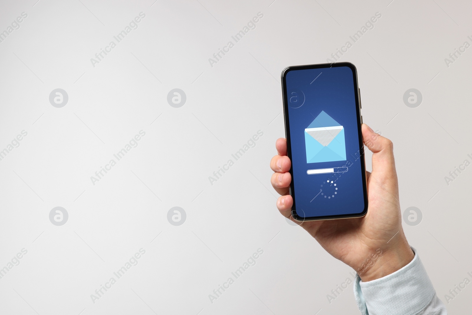 Image of Got new message. Man holding smartphone on light grey background, closeup. Space for text