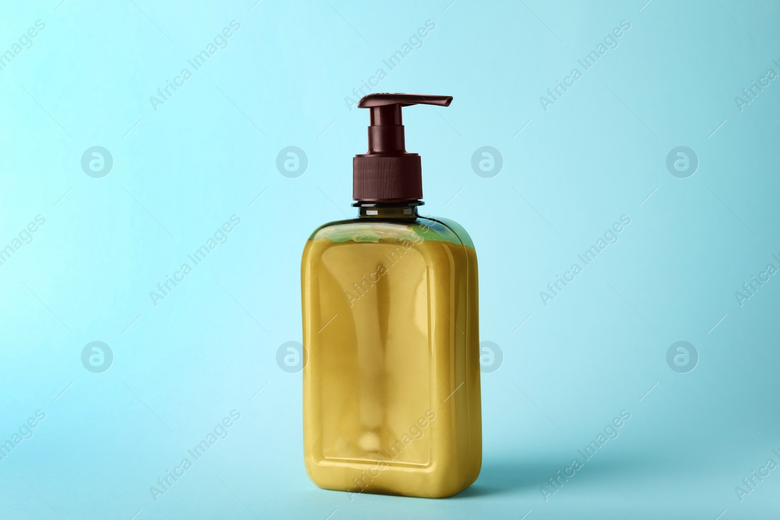 Photo of Bottle of shampoo on light blue background
