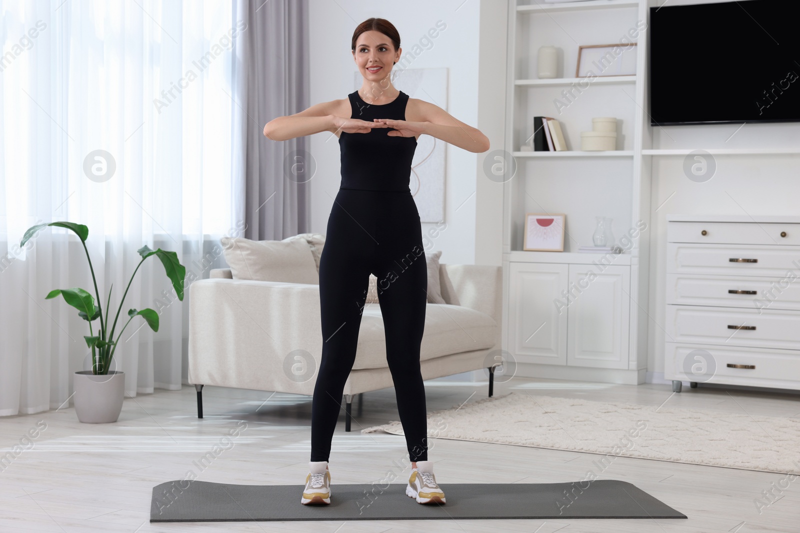 Photo of Happy woman doing morning exercise at home