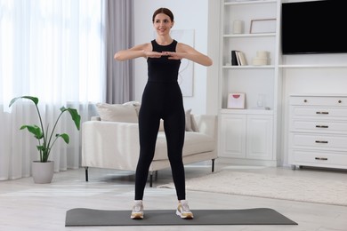 Happy woman doing morning exercise at home