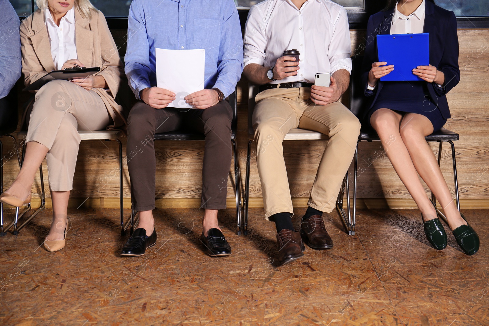 Photo of People waiting for job interview in office hall, closeup