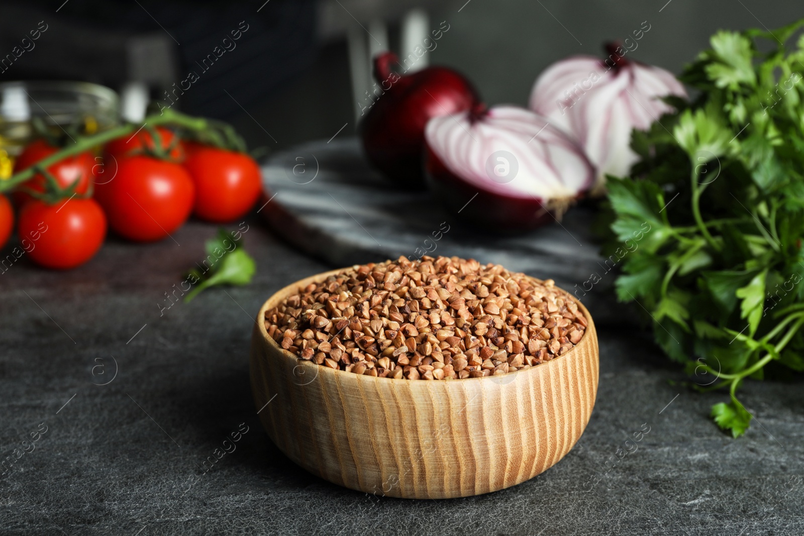 Photo of Buckwheat grains in bowl on grey table