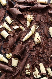 Photo of Yummy chocolate curls on black background, top view