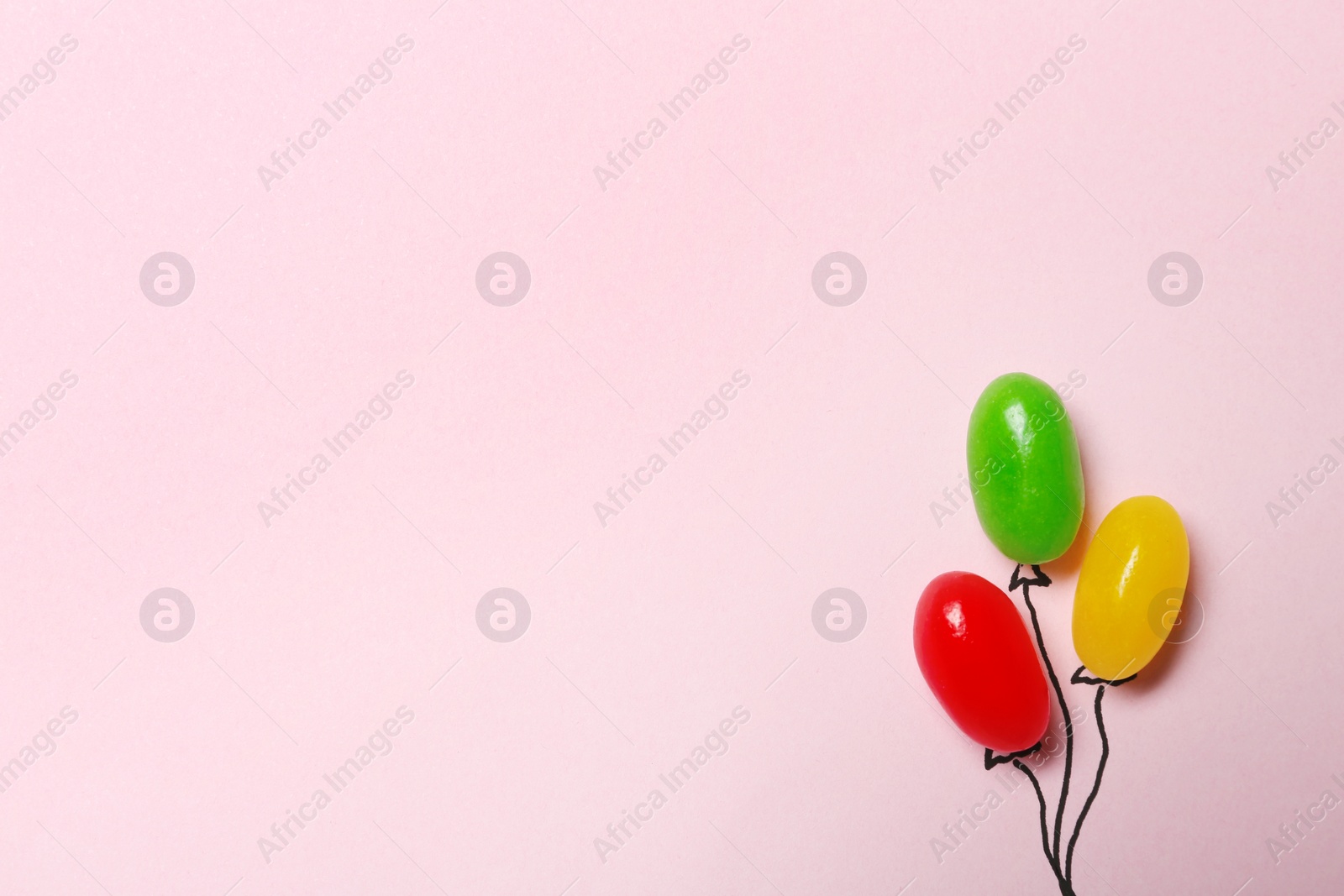 Photo of Bright jelly candies arranged as balloons on color background, flat lay. Space for text