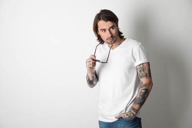 Photo of Young man with tattoos on arms against white background