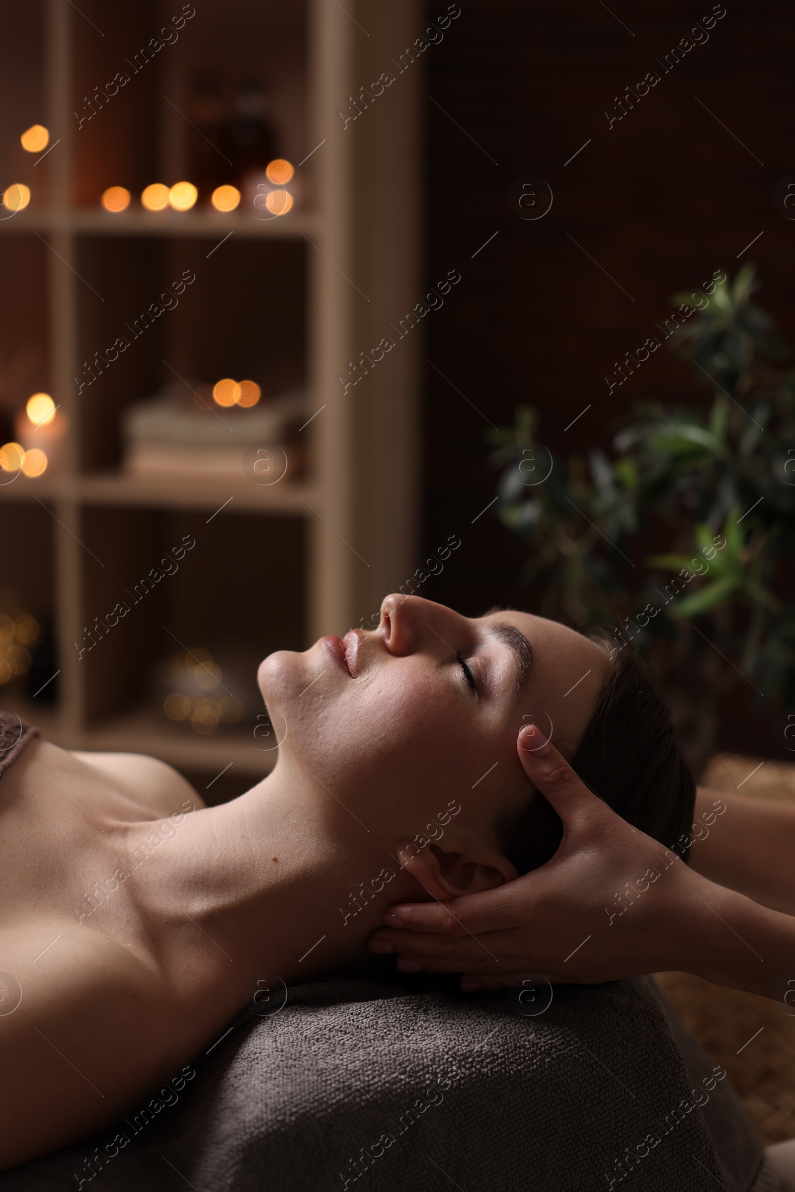 Photo of Spa therapy. Beautiful young woman lying on table during massage in salon