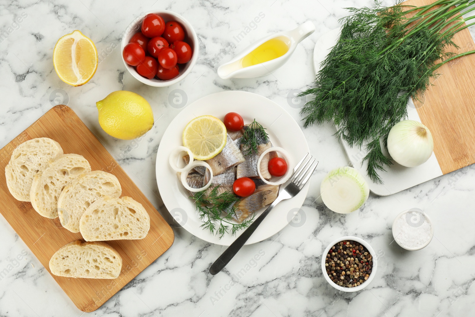 Photo of Sliced salted herring fillet served on white marble table, flat lay